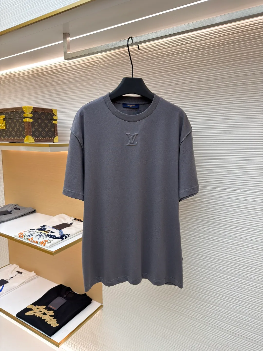 LOUIS VUITTON Concave embossed round neck short sleeves ●Original version: Purchased and developed in 5010 ●Item number: 1681360-A00 ●Fabric: plain knitted fabric ●Technology: embossed embossed production ●Color: gray ●Version: fitted version ●Weight: about 205 grams ●Size: High-count combed cotton yarn eliminates most of the short hairiness through compact spinning process, making the yarn smoother and stronger. The woven fabric structure is extremely dense, flat and soft, with excellent anti-pilling ability and durability, while retaining the natural advantages of pure cotton, which is breathable and skin-friendly. The neckline is made of 32S 1x1 rib with a weight of 300g. The finer yarn count creates a more delicate and tight thread, which provides better elasticity and deformation resistance than ordinary ribs, ensuring that the neckline can still remain stiff after being put on and taken off many times. It contains an innovative process of silicone lining. The concave and convex embossing process is heated and shaped by the upper and lower dies. The rollers press the fabric at a certain temperature, and the three-dimensional hierarchical convex surface is produced through mechanical embossing. This makes the embroidered patterns not only three-dimensional and full, but also uniquely soft and elastic to the touch, which is completely different from traditional stiff embroidery. The support of silicone also ensures that the pattern is not prone to wrinkles and deformation after washing, achieving a combination of visual novelty and process durability. The overall wiring is straight and delicate, the fabric is comfortable and soft, and the color is consistent without color difference. It can be matched with the same style to create a fashionable look and control various occasions. Customized accessories, complete with three standards, same style for men and women!